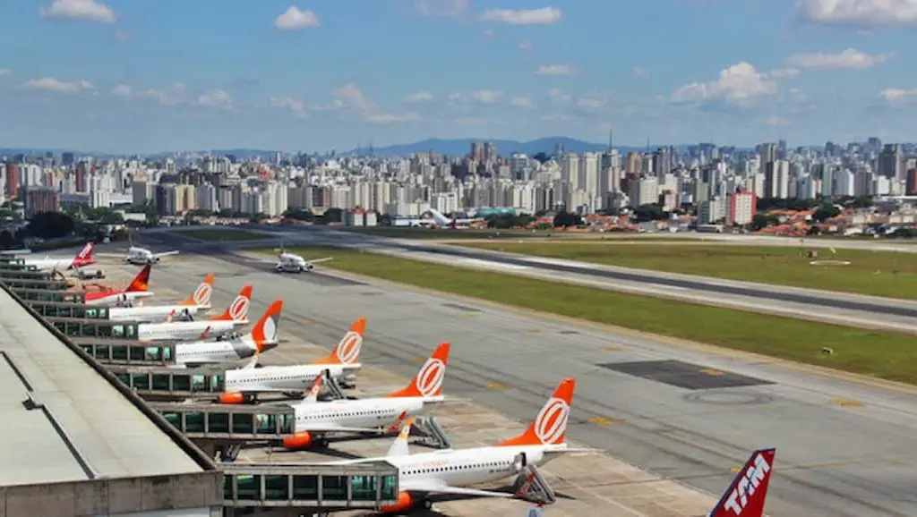 Foto da pista do Aeroporto de Congonhas com a cidade de São Paulo ao redor. 