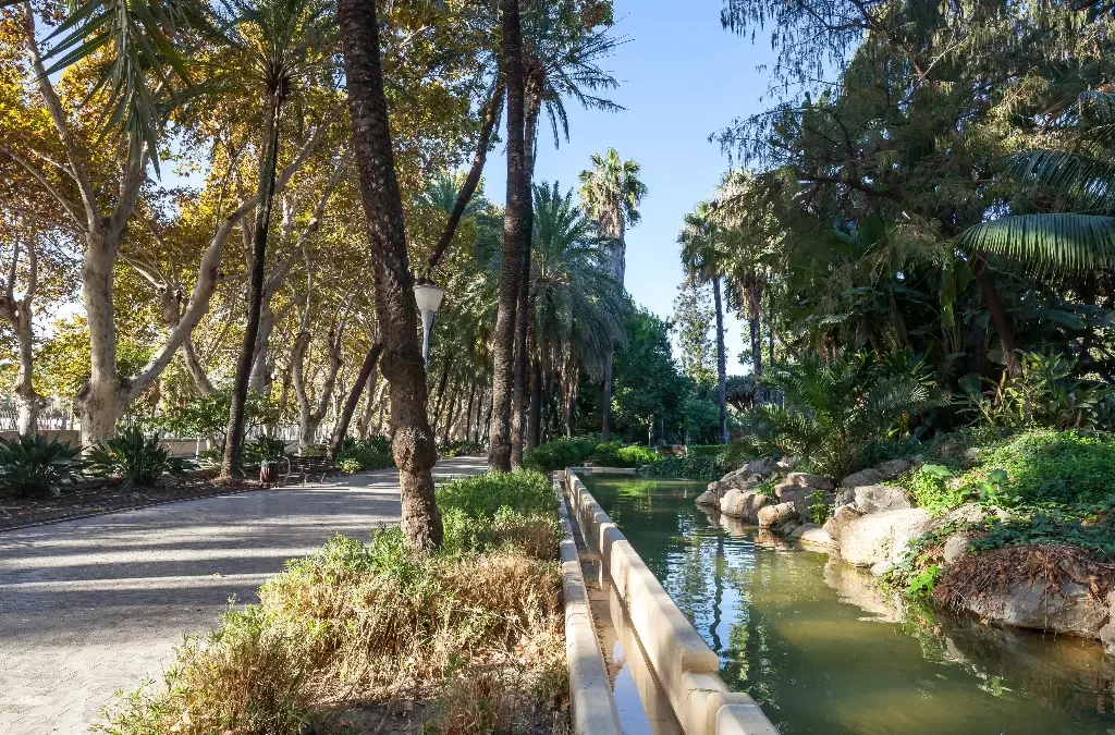 Caminhos ladeados por palmeiras e fontes no Parque de Málaga.