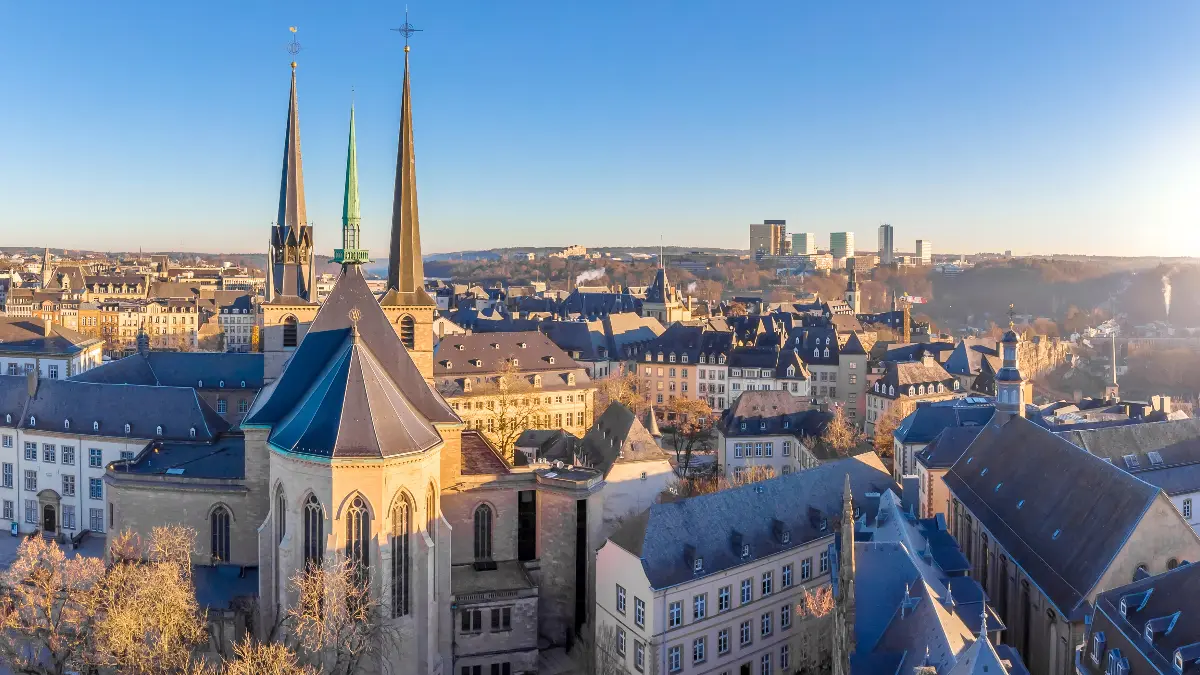 Luxemburgo pontos turísticos. Vista aérea da Cidade de Luxemburgo, destacando edifícios históricos, ruas sinuosas e espaços verdes, exemplificando os pontos turísticos icônicos de Luxemburgo.