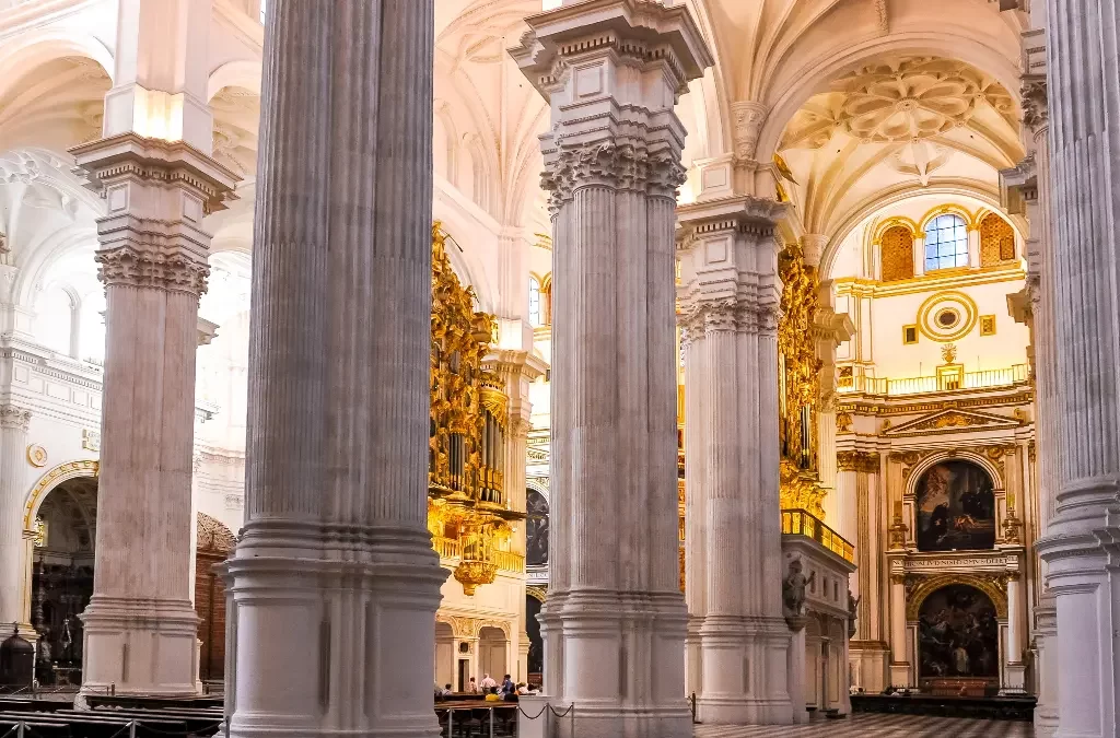 Interior majestoso da Catedral de Granada, com seus pilares elevados e vitrais, essencial na lista de o que fazer em Granada.