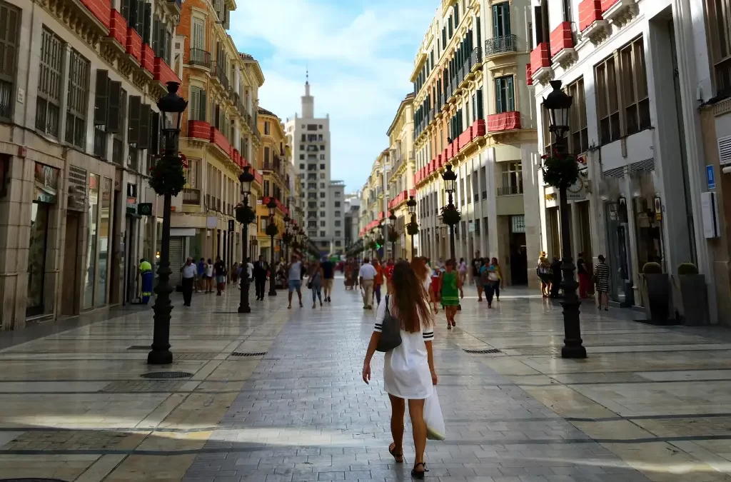 Calle Larios movimentada em Málaga, uma rua emblemática na lista de o que visitar em Málaga, com pessoas passeando e lojas em ambos os lados.