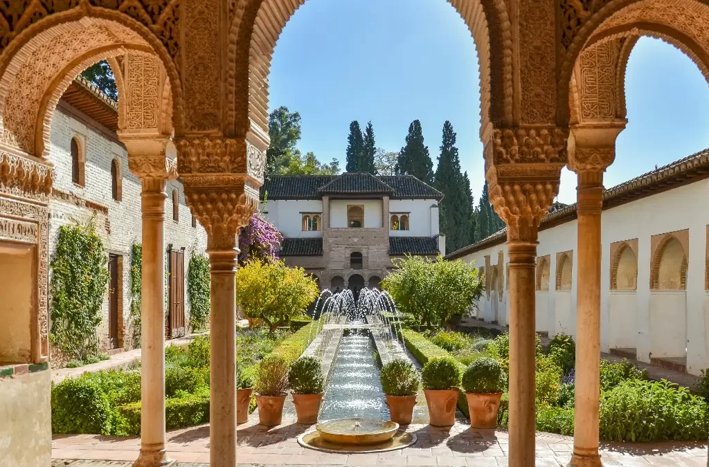 Jardins luxuriantes e corredores do Palácio de Generalife em Alhambra, exemplificando a beleza histórica na lista de o que visitar em Granada