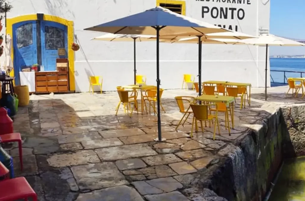Mesas ao ar livre do restaurante Ponto Final com vista para o rio Tejo